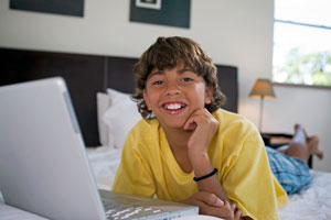 Boy in yellow shirt on a laptop
