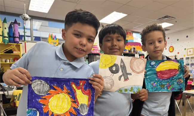Elementary school boys show off pictures they drew