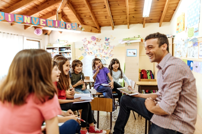 Young man teaches a class of elementary students