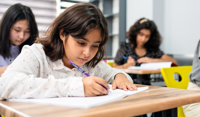 Elementary school student writing in a notebook