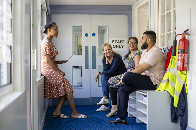 Teachers talk to each other in a staff only area in school